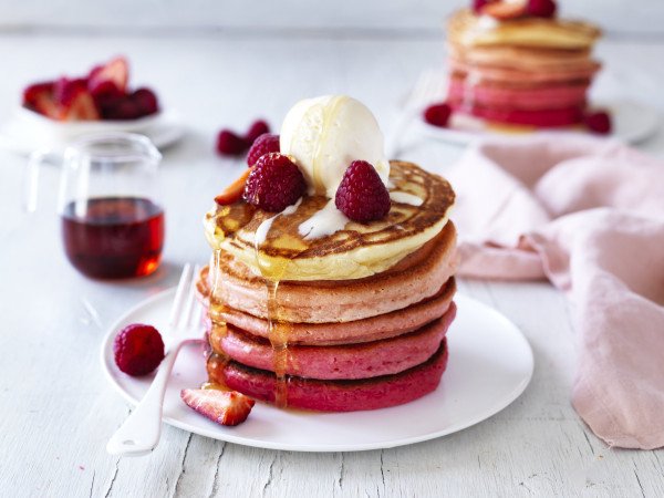 pink ombre pancake stack topped with cream and berries