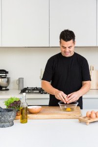 Warren cracking eggs into a bowl