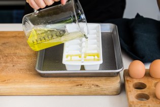 Pouring egg whites into ice cube tray