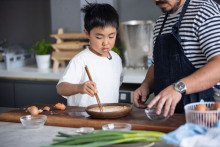 Adam Liaw teaching his son Christopher how to cook