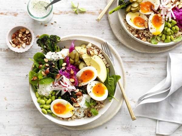 a veggie bowl with hardboiled eggs, legumes, salad leaves and nuts