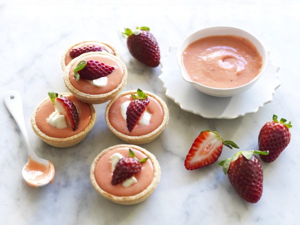 5 strawberry curd tarts topped with strawberries and cream