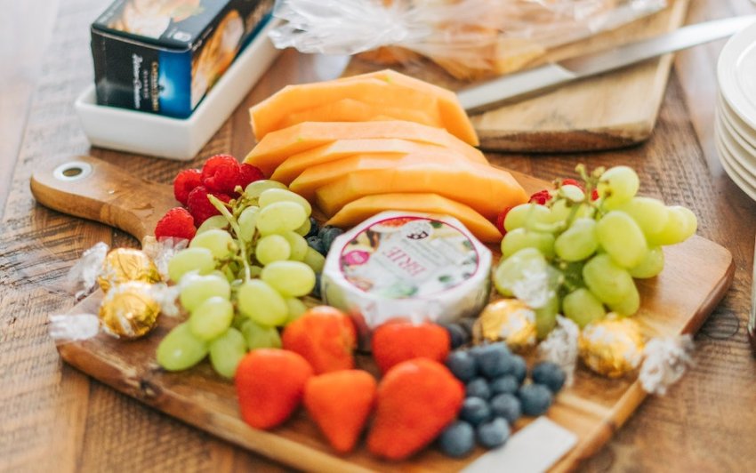 cheese and fruit on a board