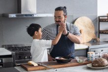 Adam Liaw celebratory high fives in the kitchen. 