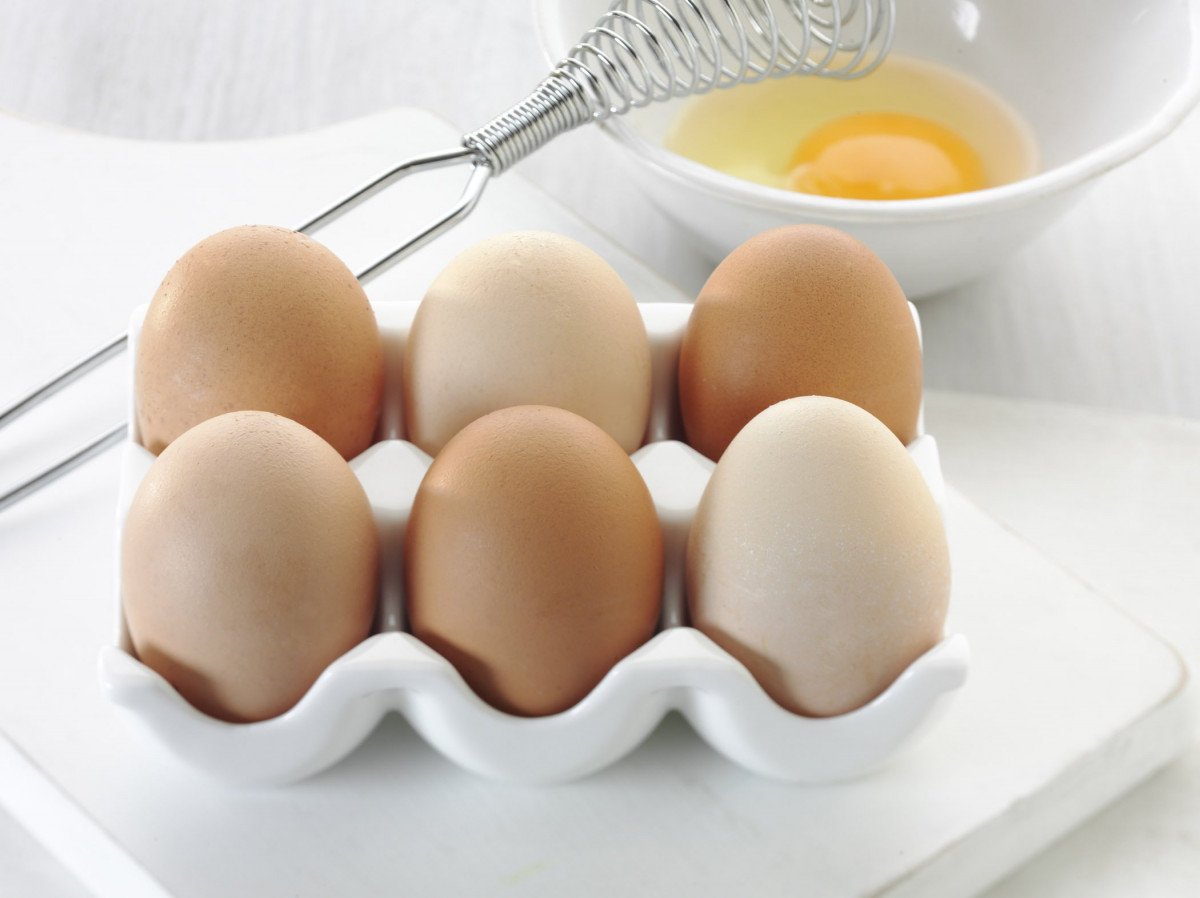 Six eggs with cracked egg behind