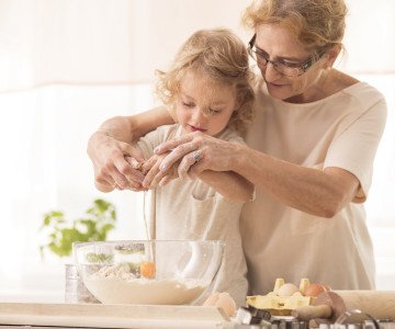 Woman cracking egg with child