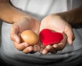 woman holding egg and heart